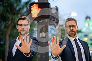 Business men doing stop sing with hand. Warning expression with negative and serious gesture. Stop hand gesture
