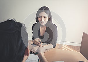 Business man handing pen to a woman for contract signing