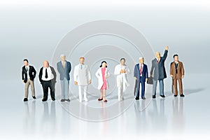 Business men lining up with doctors and nurses supporting them to fight together. Miniature people figure