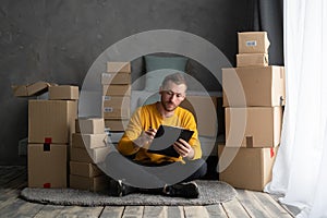 business men sit on floor checking customer order online shipping boxes at home. Starting Small business entrepreneur