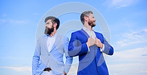 Business men stand blue sky background. Business people concept. Well groomed appearance improves business reputation photo