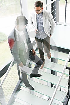 Business men standing on the stairs. Business people having conv