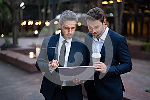 Business men with takeaway coffee and laptop outdoor were strategic in their planning. Business men were effective