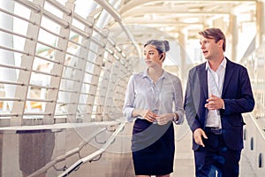 Business men talk to business women While walking and resting on the Skywalk, Teamwork, partnership concep