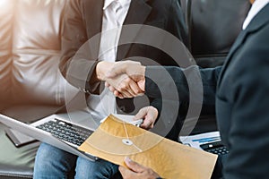 Business men and women shake hands confidently at an office meeting