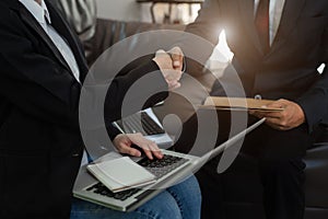 Business men and women shake hands confidently at an office meeting