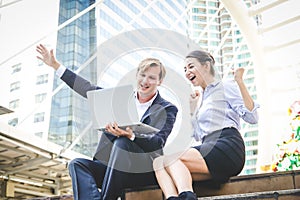 Business men and women sit and talk on the outdoor stairs