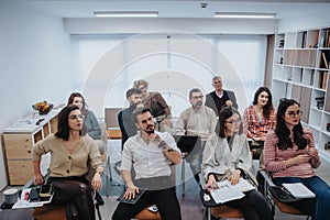 Business men and women of various ages engaging in a business workshop in a contemporary office setting, exemplifying