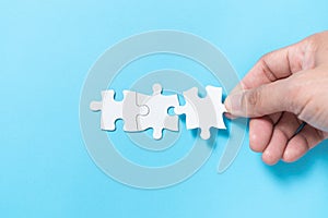 Business merging concept using white jigsaw puzzle