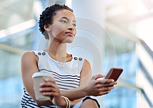 Business mindedness Activated. an attractive young businesswoman looking thoughtful while using a smartphone in a modern