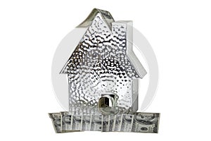 Business, money and finance concept. A metallic house model with many $100 banknotes isolated on a white background. Real estate