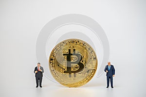 Business , Money, Technology and  cryptocurrency Concept. Two businessman miniature figure people standing with gold bitcoin coins