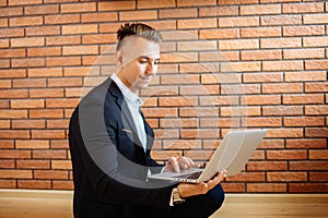 Business man using laptop at home while sitting on floor