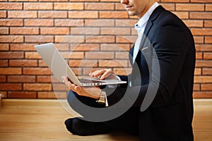 Business man using laptop at home while sitting on floor