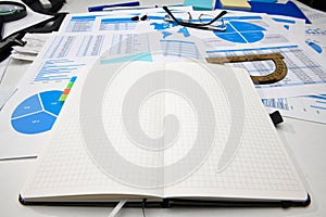 Business office desk closeup - financial reports, analysis and accounting, set of documents, tables and graphs, various items for