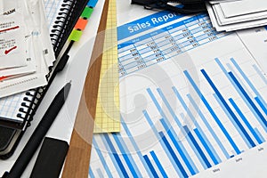 Business office desk closeup - financial reports, analysis and accounting, set of documents, tables and graphs, various items for