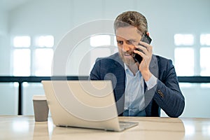 Business office interior. Businessman chatting phone online in office. Business man in suit using phone. Office worker