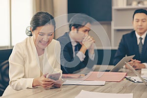 Business In an office meeting, a business beautiful woman dressed in a suit is chatting on her phone