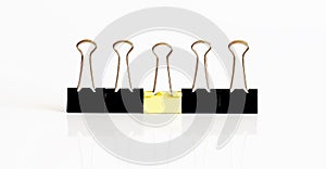 Business, office supplies, leadership, unique, individuality or think different concept : yellow clip leader amount black clips