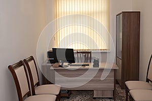 Business office with wooden table, chairs and wardrobe