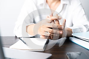 A business office worker is an asian woman is sitting in front of the laptop computer. A businesswoman stressing her body part