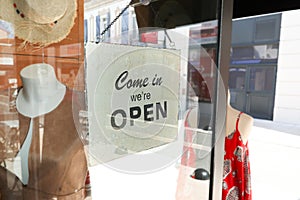 Business opening with open entrance sign in street shop through the glass