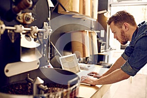 Business owner of a coffee roastery checking his laptop