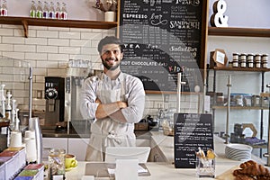 Business owner at the counter of coffee shop, arms crossed