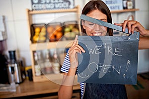 Business owner holding Open Sign. woman opening her store