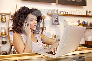 Business owner on the phone and typing laptop