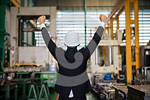 Business owner raise hands in factory warehouse