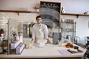 Business owner standing behind the counter at a coffee shop