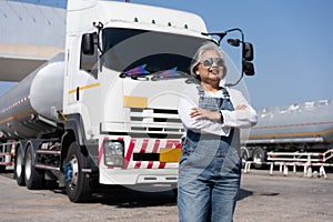 Business owner standing in front of oil truck after performing a pre-trip inspection on a truck. Concept of preventive maintenance