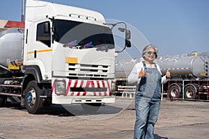 Business owner standing in front of oil truck after performing a pre-trip inspection on a truck. Concept of preventive maintenance