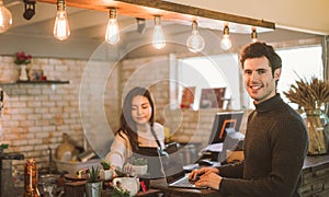 Business owner using laptop working with laptop at the bar of the modern cafe.