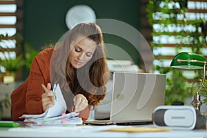 Business owner woman in green office working with documents