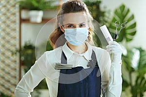 Business owner woman with mask, gloves, hair comb and scissors