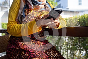 Business owner young  25s Muslim woman wearing hijab working with  payments app smartphone