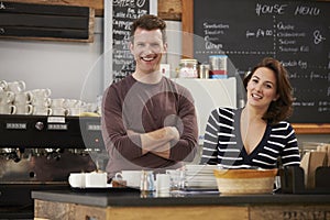 Business owners behind the counter at their cafe, close up