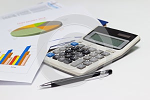 Business paper graphs and pen with charts report, calculator on desk of financial planning