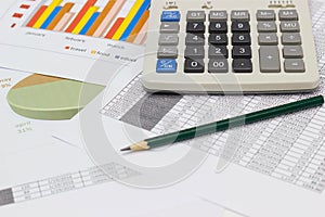 Business paper graphs and pencil with charts report , calculator on desk