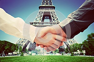 Business in Paris, France. Handshake on Eiffel Tower background