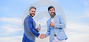 Business partner confirming deal transaction. Men formal suits shaking hands blue sky background. Entrepreneurs shaking