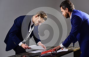 Business partner signs the document under pressure. Unfavorable deal concept.