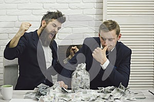 Business partners, businessmen at meeting in office. Cash issues concept. Bearded boss angry and colleague with jar of