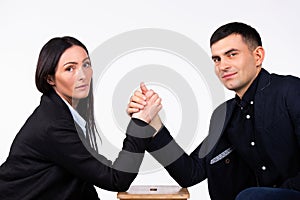 Business partners are competing and looking at the camera. Arm wrestling on a white background.