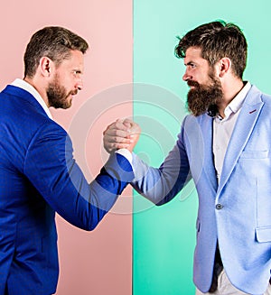 Business partners competitors office colleagues tense faces ready to compete in arm wrestling. Hostile or argumentative