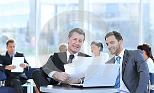 Business partners discuss financial issues sitting in the lobby of the Bank