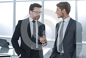 Business partners discuss standing in the office