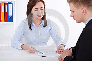 Business partners discussing documents and strategic planing at meeting. Office background. Businesswoman and Businessman.